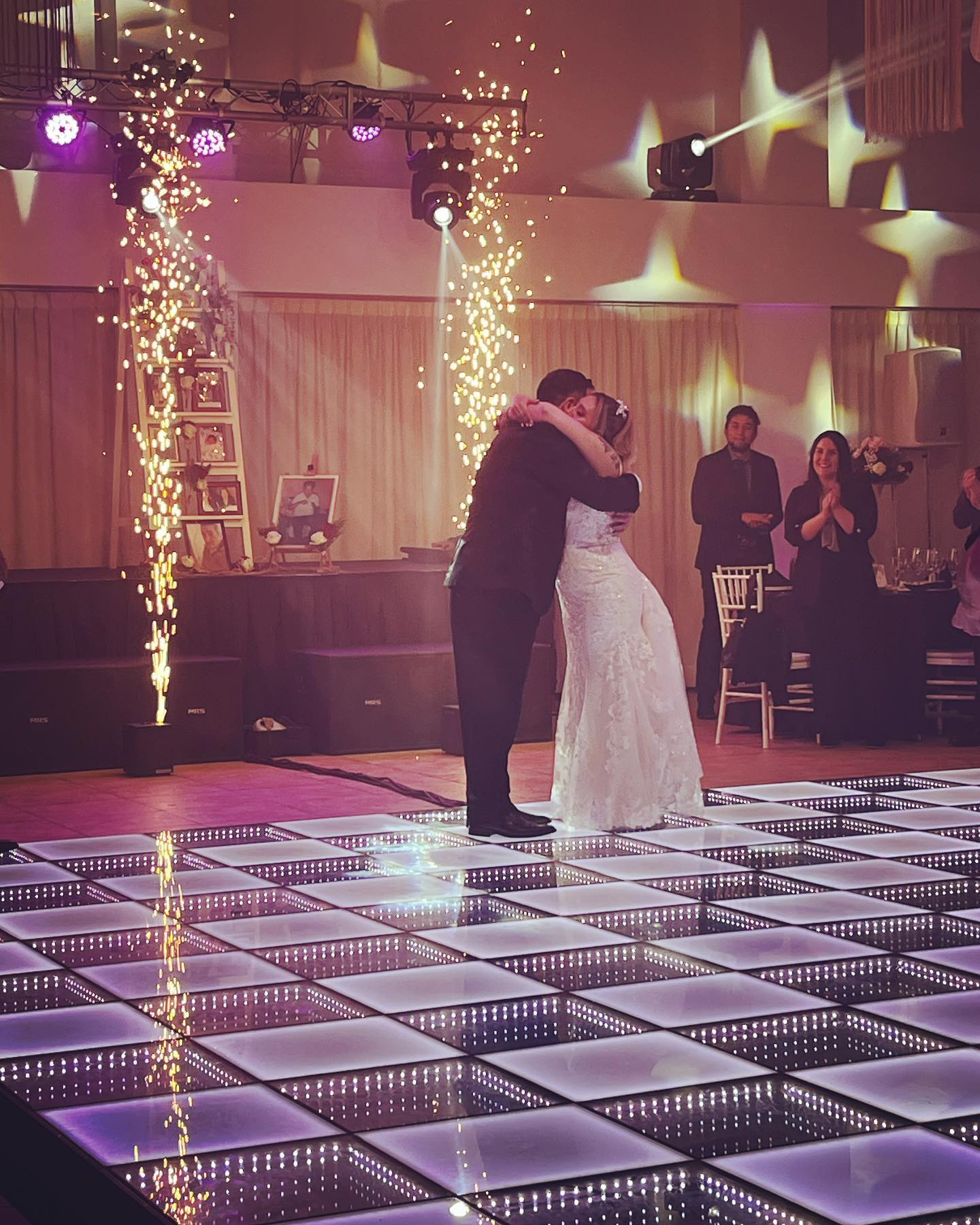 Bride and groom first dance on LED dance floor with sparklers